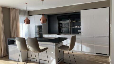 Referenz weiße hochglanzküche von der Marke LEICHT Modell Avance, elektrischer Rolloschrank, Kücheninsel, Barplatte, Geräte von Gaggenau und Miele